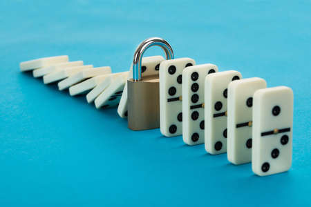 Domino And Lock In A Row Over Blue Background