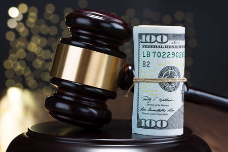 Close-up Of Wooden Gavel With Rolled Banknote Tied With Rope