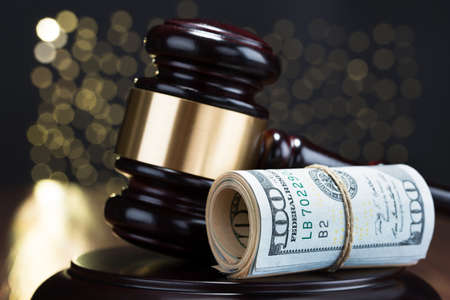 Close-up Of Wooden Gavel With Rolled Banknote Tied With Ropeの写真素材