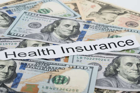 Close-up Of Health Insurance Text On Piece Of Paper With Banknotesの写真素材