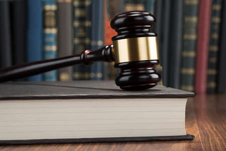 Close-up Of Wooden Gavel With Book On Tableの写真素材