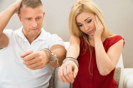 Portrait Of Unhappy Young Couple Handcuffed Togetherの写真素材