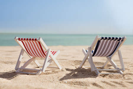 Photo Of Two Miniature Deckchairs On Sunny Beachの写真素材