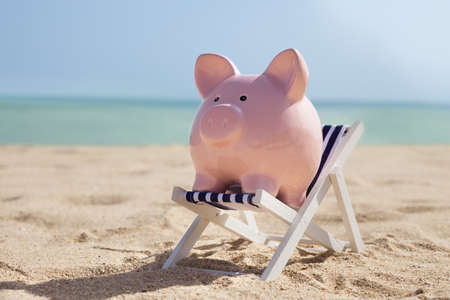 Piggy Bank With Deckchair On Sandy Beachの写真素材