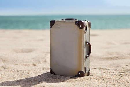 Retro Miniature Old Suitcase On Sunny Beachの写真素材