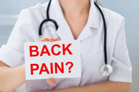 Close-up Of Female Doctor Holding Placard With Text Back Pain