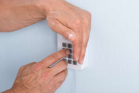 Close-up Of A Hand Entering Pin In Security System