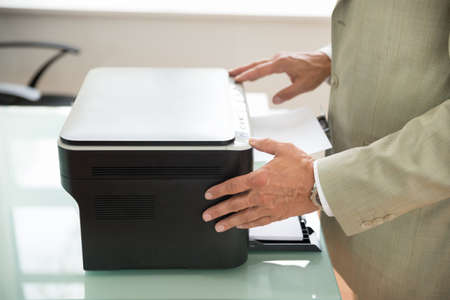 Close-up Of A Mid-adult Businessman Using Photocopy Machine In Office
