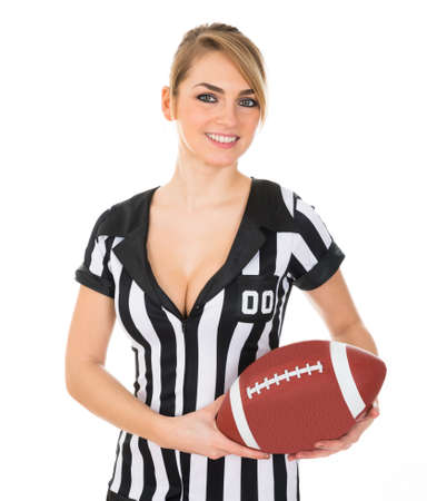 Young Beautiful Female Referee Holding American Footballの写真素材