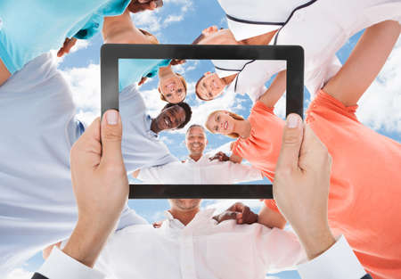 Person Hand Photographing Group Of People Standing In Circleの写真素材