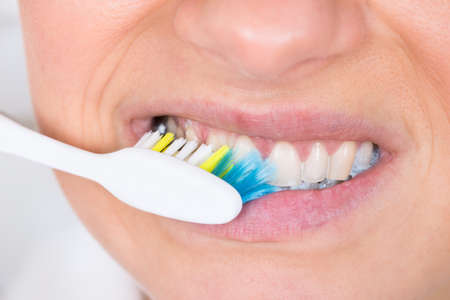 Close-up Of A Woman Brushing Teeth With Toothbrushの写真素材
