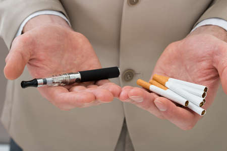 Close-up Of Businessperson Hand Holding Electronic Cigarette