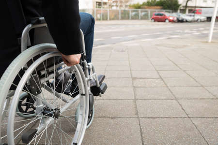 Close-up Of Disabled Man Sitting On Wheelchairの写真素材