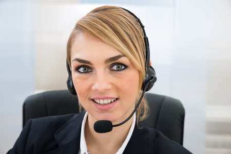 Close-up Of Smiling Female Customer Service Representative With Microphone