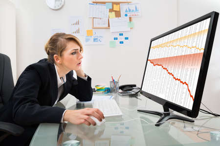 Young Businesswoman Watching Finance Collapse Graph On Computer Monitor