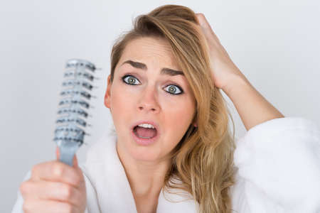 Worried Woman Suffering From Hairloss Looking At Combの写真素材