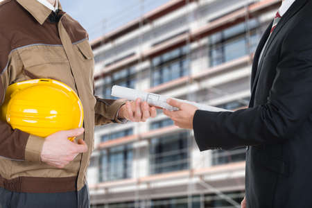 Close-up Of A Businessman Giving Blueprint To Architectの写真素材
