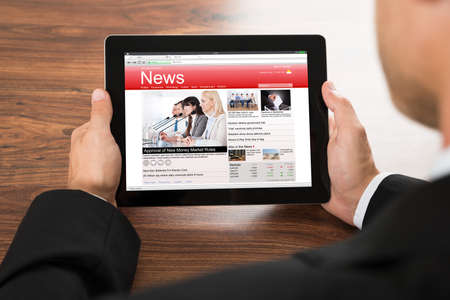 Close-up Of A Businessman Reading Online News On Digital Tabletの写真素材