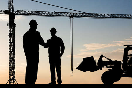 Silhouette Of Two Architect At Construction Site Shaking Handの写真素材
