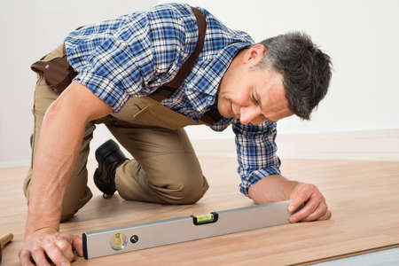 Carpenter Installing New Laminated Wooden Floor At Home