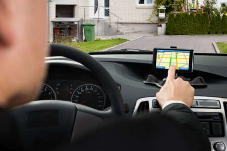 Close-up Of A Businessman Using Gps Navigation System In Car