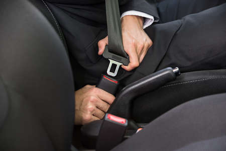 Close-up Of A Man Sitting In Car Fastening Seat Beltの写真素材