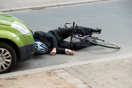 Unconscious Male Cyclist Lying On Road After Road Accidentの写真素材