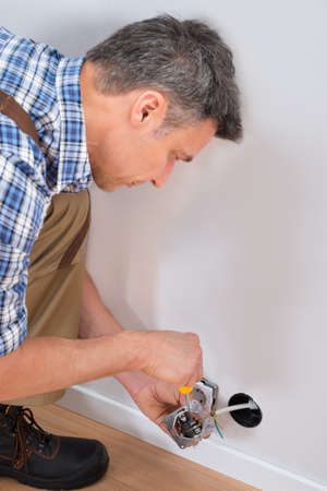 Close-up Of A Male Technician Fixing Socket With Screwdriverの写真素材