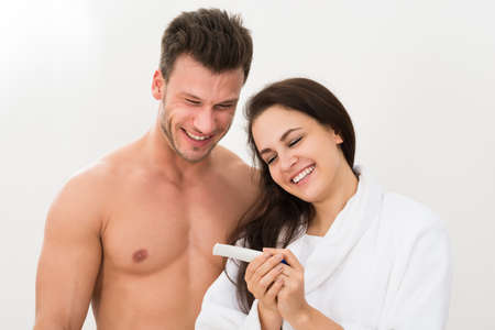 Smiling Young Couple Finding Out Results Of A Pregnancy Testの写真素材