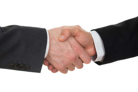 Close-up Of Two Businessman Shaking Hands Over White Backgroundの写真素材