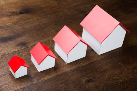 Different Size Houses In Row On Wooden Tableの写真素材