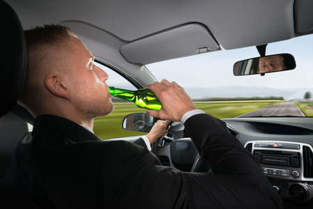 Close-up Of A Businessman Drinking Beer While Driving Car