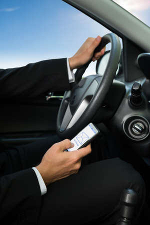 Close-up Of A Man Holding Cellphone While Driving Car
