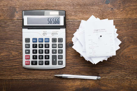 High Angle View Of Receipts With Calculator And Pen On Tableの写真素材