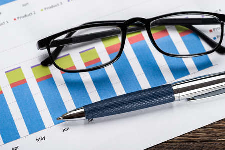 Close-up Of A Eyeglasses And Ballpen On Financial Graphの写真素材