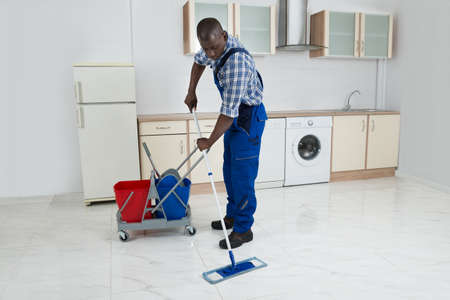 African Male Worker In Overall Cleaning Floor With Mopの写真素材