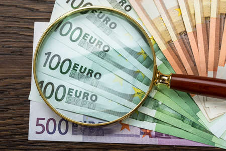Close-up Of Magnifying Glass Over Euro Banknoteの写真素材
