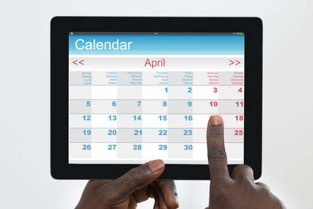 Person Holding Digital Tablet With Calendar Application On Screen