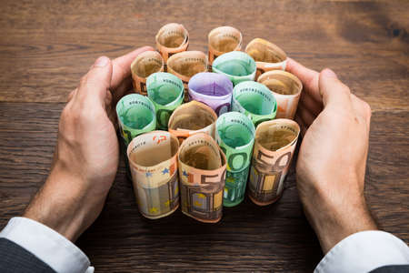 Close-up Of A Businessman's Hand Protecting Euro Banknotes