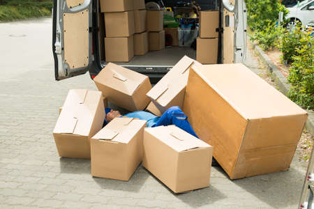 Unconscious Male Worker Lying On Street Surrounded With Boxes