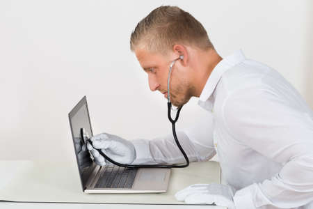 Male Technician With Stethoscope And Laptop At Desk
