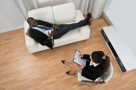 Young African Patient Telling Problem To Professional Psychiatristの写真素材