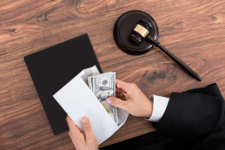 Close-up Of Judge Removing Money From Envelope In Courtroomの写真素材