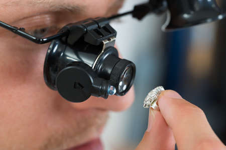 Close-up Of Jeweler Looking Ring Through Magnifying Loupe
