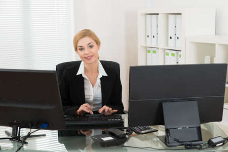 Young Happy Businesswoman Working On Computer At Desk