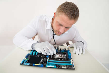 Technician Listening To Cpu Processor In Motherboard With Stethoscopeの写真素材