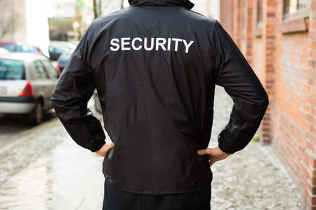 Close-up Of Male Security Guard Wearing Black Jacket