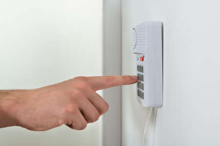Close-up Of Person Hand Pressing Button On Door Security System