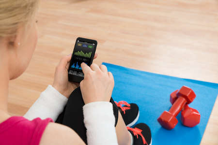 Close-up Of Woman With Mobile Phone Showing Pulse Rate