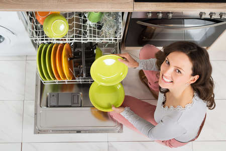 High Angle View Of Young Woman Doing Housework In Kitchenの写真素材